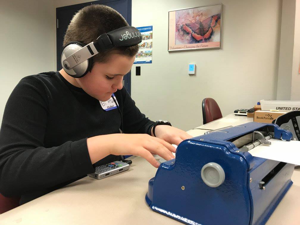 Child using braille machine WA State