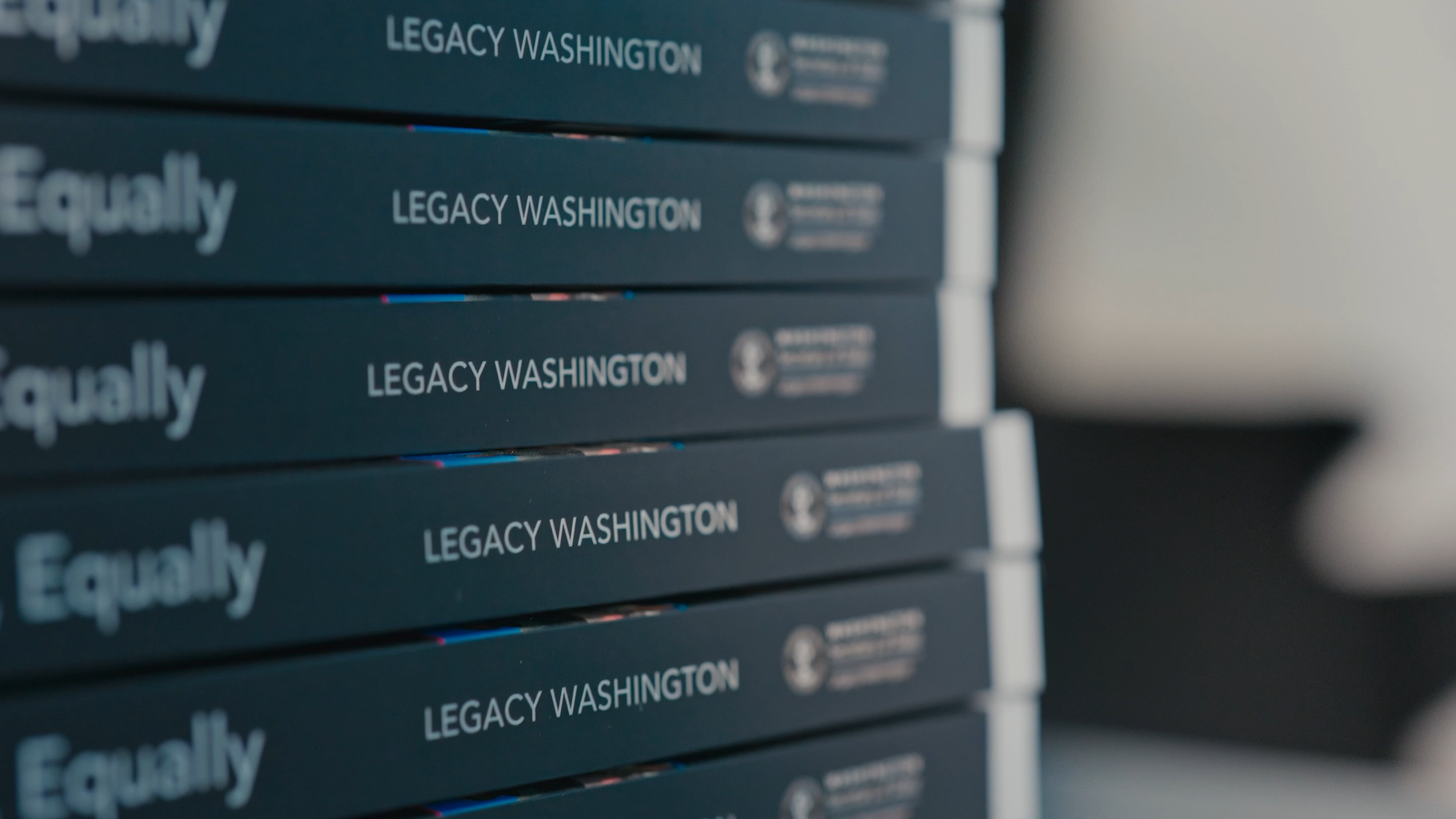 Stack of Legacy WA books showing the "Legacy Washington" print on spine